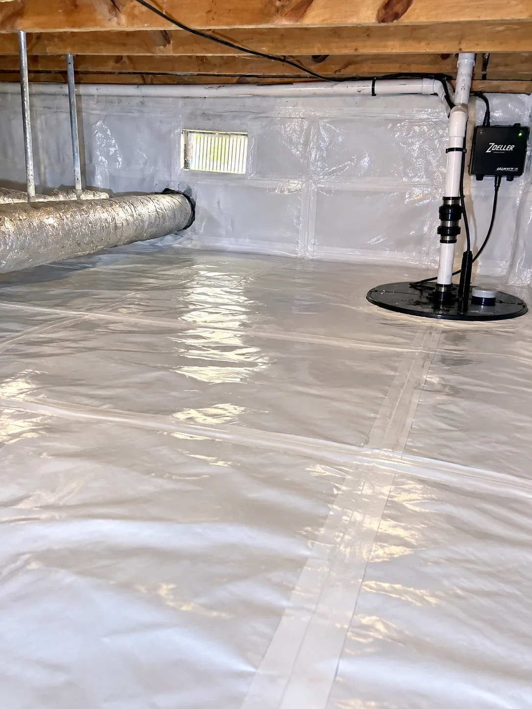 Owner-supplied photo of a finished Hampton Roads crawl space with a sealed vapor barrier and installed sump pump